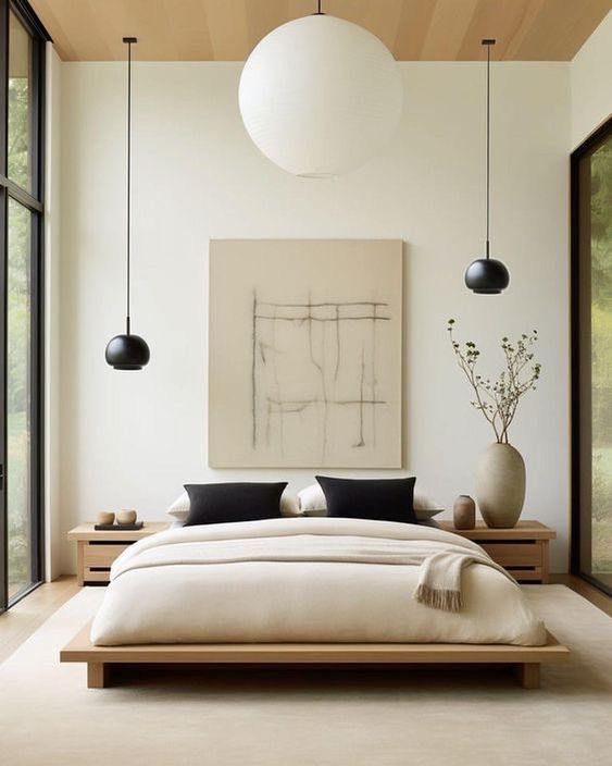 beige bedroom with black pillows and a minimalist painting